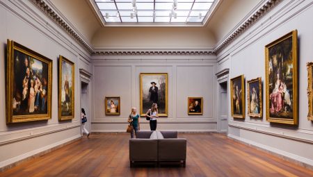 Two women walk through an art gallery