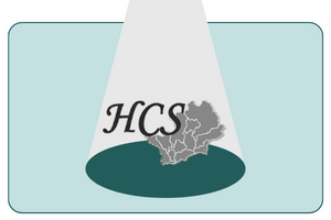 A spotlight shines on the HCS logo