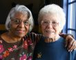 Two older ladies pose for a photo together