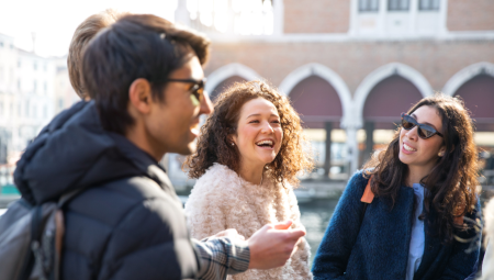 Mixed group of millennials chatting together and smiling.