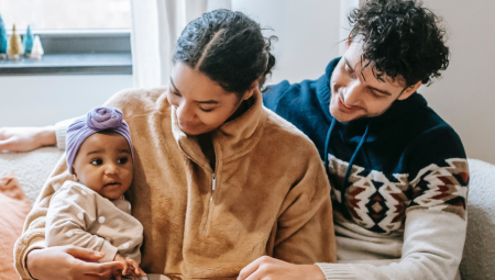 A young couple holding their new born baby