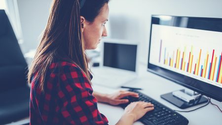Woman looks at bar charts on her computer