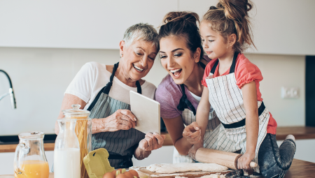 A grandmother in the kitchen with her daughter and granddaughter