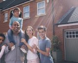 Family stand outside their home