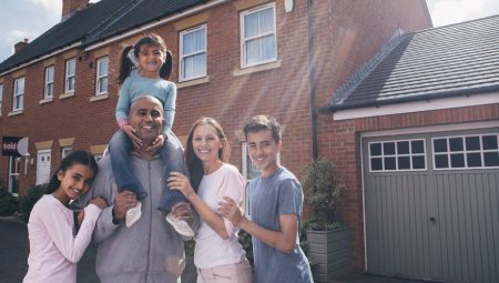 Family stand outside their home