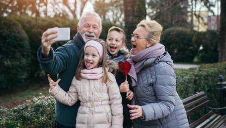 Grandparents pose for a selfie with their two young grandchildren