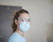 Woman wearing face shield and medical mask
