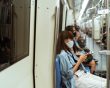 Woman wearing a mask sitting on a train